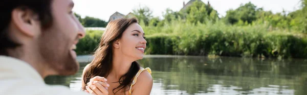 Donna felice sorridente e guardando lontano vicino fidanzato allegro e sfocato, banner — Foto stock