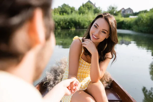 Cheerful woman holding hands with blurred boyfriend during boat ride — Stock Photo