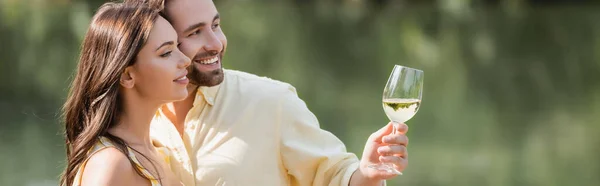 Romantique jeune homme tenant verre avec vin près femme heureuse, bannière — Photo de stock