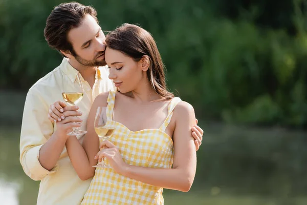 Romantic couple in summer clothes holding glasses with wine — Stock Photo