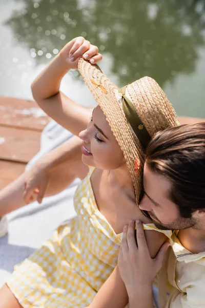 High angle view of bearded man hugging happy girlfriend in straw hat — Stock Photo