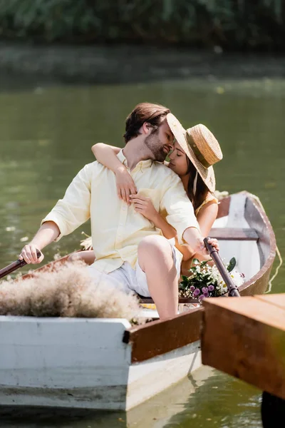 Jeune femme en paille chapeau baisers homme pendant romantique bateau voyage — Photo de stock