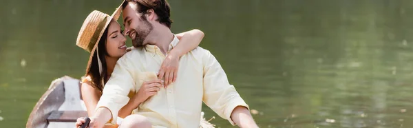 Heureuse jeune femme en chapeau de paille étreignant l'homme pendant le voyage romantique en bateau, bannière — Photo de stock