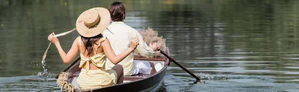 Back view of woman in straw hat having boat ride with boyfriend, banner — Stock Photo
