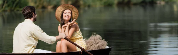 Mulher sorridente em chapéu de palha ter passeio de barco romântico com o homem, banner — Fotografia de Stock