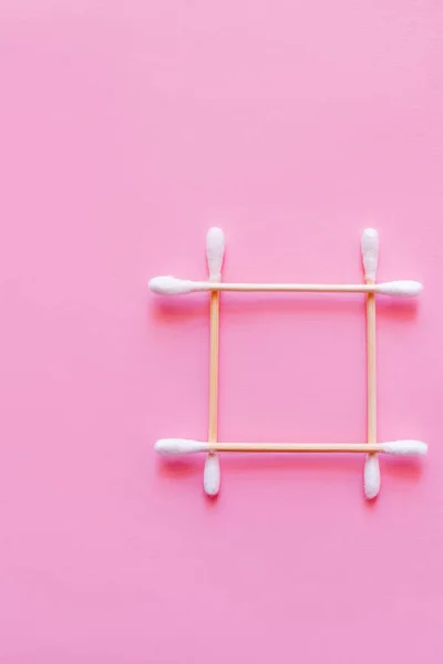 Top view of square made of cotton swabs on pink background - foto de stock