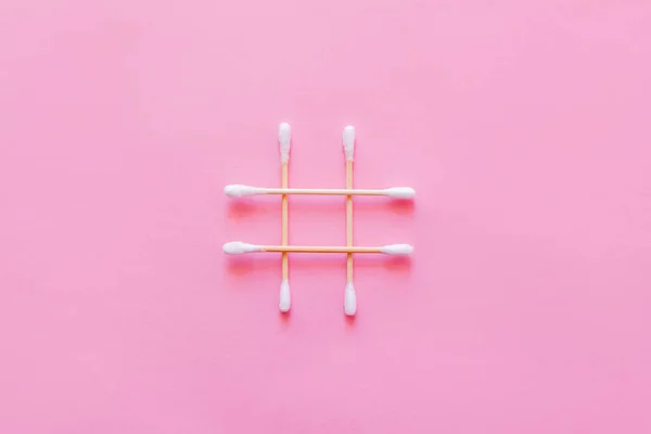 Top view of crossed cotton swabs on pink background — Stockfoto