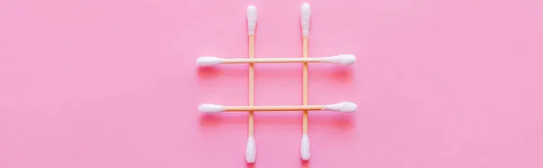 Top view of cotton swabs crossed on pink background, banner — Fotografia de Stock