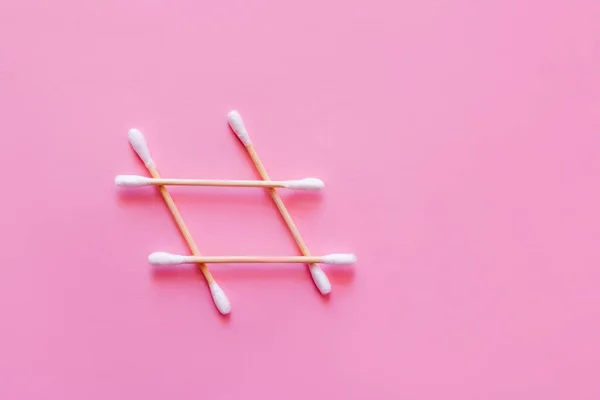 Top view of grid made of cotton swabs on pink background — Photo de stock