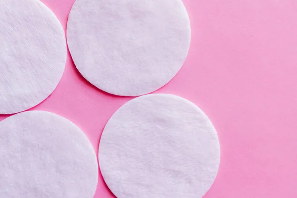 Close up of white cotton pads on pink background, top view — Stockfoto