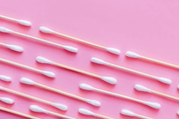 Top view of diagonal lines of cotton swabs on pink background - foto de stock
