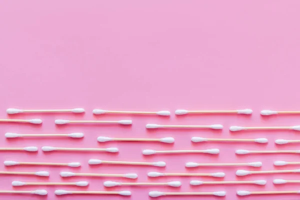 Horizontal rows of cotton swabs on pink background, top view — Photo de stock