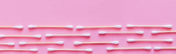 Top view of rows of hygienic cotton swabs on pink background, banner — Stock Photo