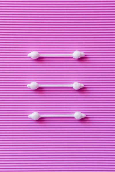 Top view of three cotton swabs on purple textured background — Stock Photo