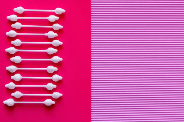 Top view of cosmetic cotton swabs on bicolor pink and purple background — Photo de stock
