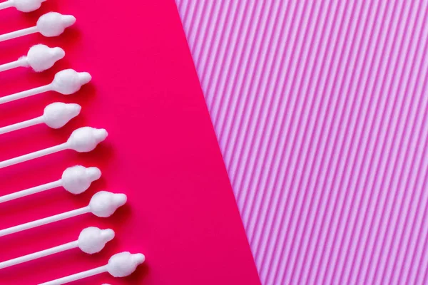 Top view of cosmetic cotton swabs on bright pink and violet background — Stock Photo
