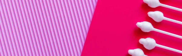 Top view of cotton swabs on textured violet and pink background, banner - foto de stock