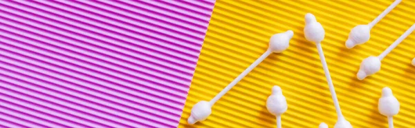 Top view of ear sticks on yellow and violet textured background, banner — Stock Photo