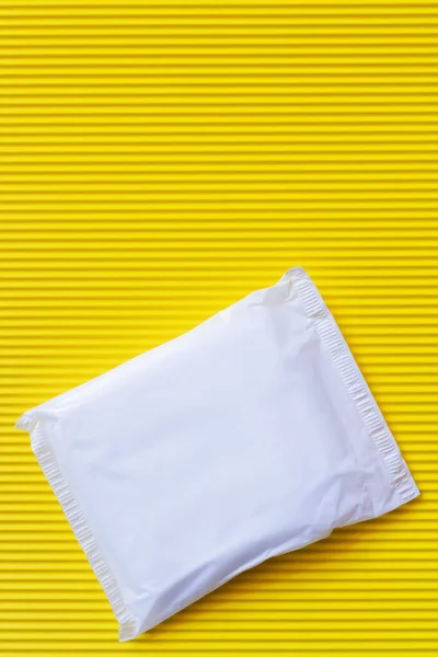 Top view of packed panty liner on textured yellow background — Stock Photo