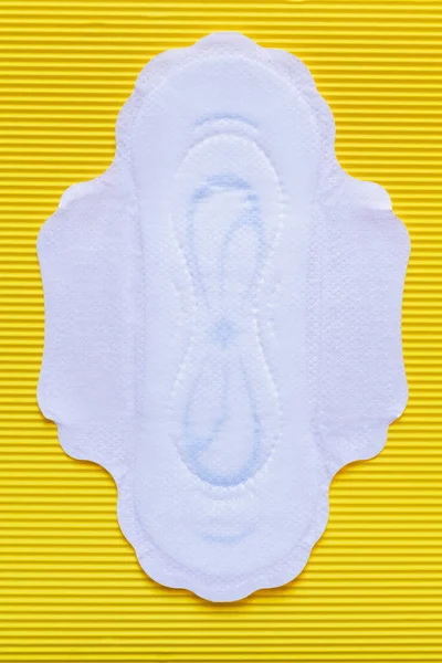 Top view of white soft panty liner on yellow textured background — Stock Photo