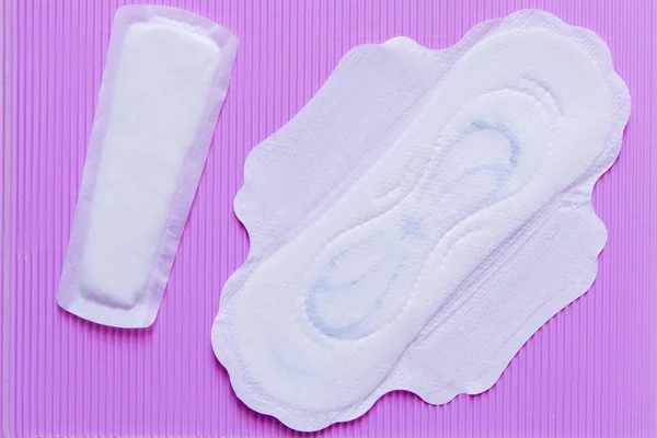 Top view of white panty liners on violet textured background — Photo de stock