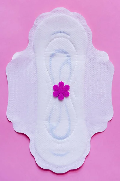 Top view of white panty liner with purple flower on violet background — Stock Photo