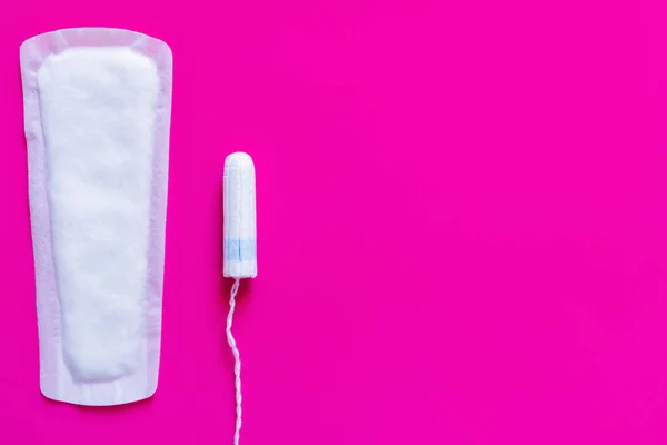 Top view of white panty liner and tampon on purple background — Foto stock