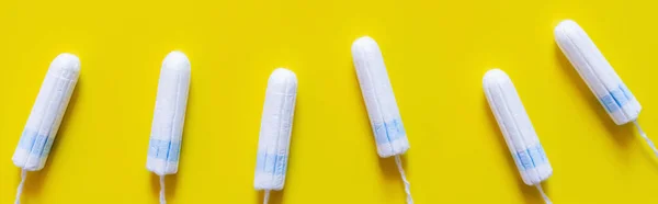 Top view of white cotton tampons on bright yellow background, banner — стоковое фото