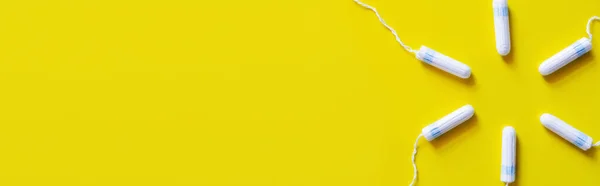Top view of circle made of tampons on yellow background with copy space, banner — Fotografia de Stock