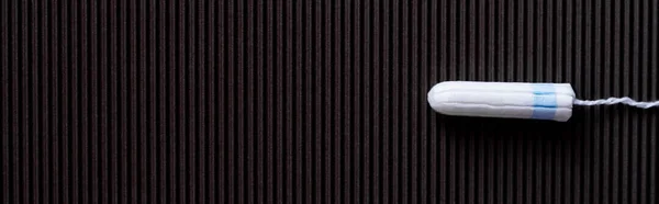 Top view of white hygienic tampon on black textured background, banner - foto de stock