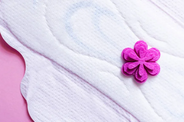 Close up of white panty liner with purple flower on violet background, top view — Photo de stock
