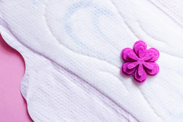 Primer plano de panty liner blanco con flor púrpura sobre fondo violeta, vista superior — Stock Photo