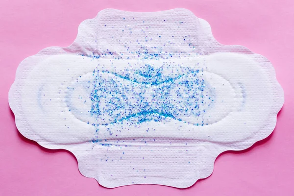 Top view of white panty liner with sequins on violet background - foto de stock