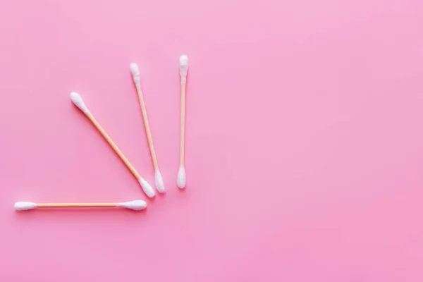Top view of ear sticks on pink background with copy space — стоковое фото