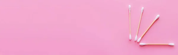 Vista superior de hisopos de algodón cosméticos sobre fondo rosa con espacio para copiar, pancarta - foto de stock