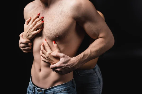 Cropped view of woman touching torso of boyfriend isolated on black — Fotografia de Stock