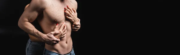 Cropped view of young woman touching sexual boyfriend isolated on black, banner — стоковое фото