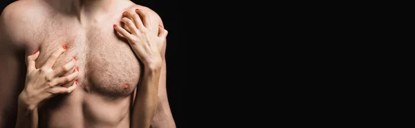 Cropped view of woman scratching chest of shirtless man isolated on black, banner - foto de stock