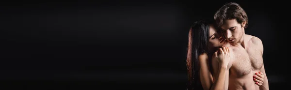 Sensual woman embracing muscular man isolated on black, banner — Foto stock