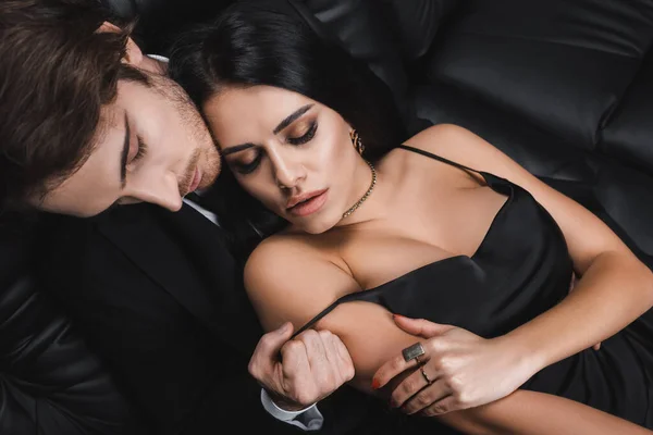 Overhead-Ansicht leidenschaftlicher Mann zieht Kleid von sinnlicher Freundin auf Couch aus — Stockfoto
