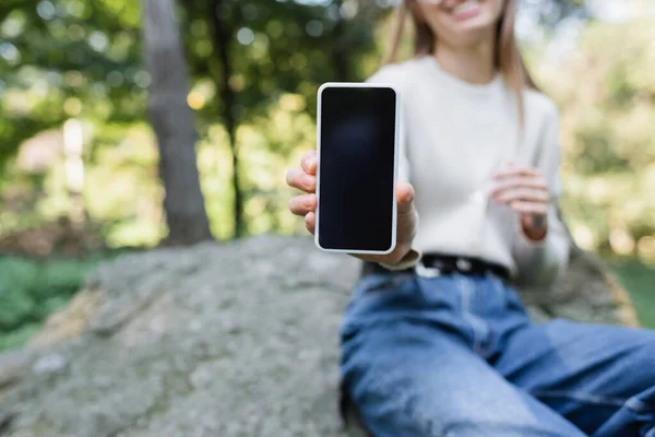 Vista cortada de mulher feliz segurando smartphone com tela em branco — Fotografia de Stock