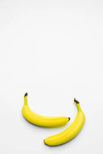 Вид зверху на жовті банани на білому тлі з пробілом для копіювання — стокове фото