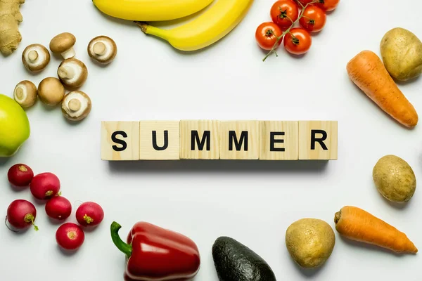 Vista dall'alto dei cubi con scritte estive vicino al cibo fresco su sfondo bianco — Foto stock