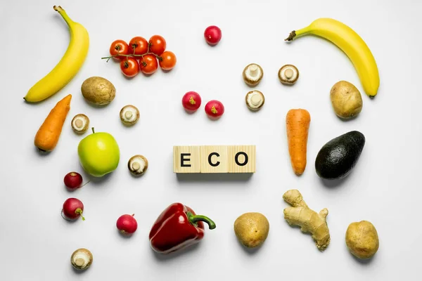 Top view of cubes with eco lettering near organic food on white background - foto de stock