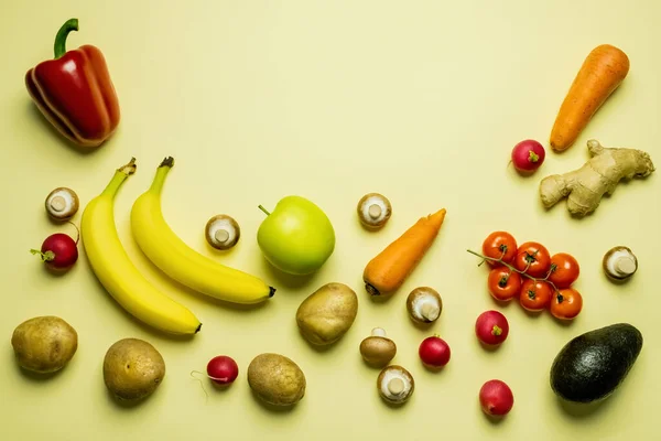 Плоский лежак зі стиглими фруктами та овочами на жовтому фоні — стокове фото