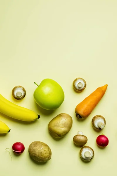 Vue du dessus des légumes entiers près des fruits sur fond jaune avec espace de copie — Photo de stock