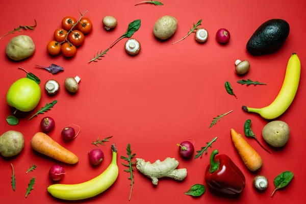 Flache Lage mit Rahmen aus frischem Gemüse und Obst auf rotem Hintergrund — Stockfoto