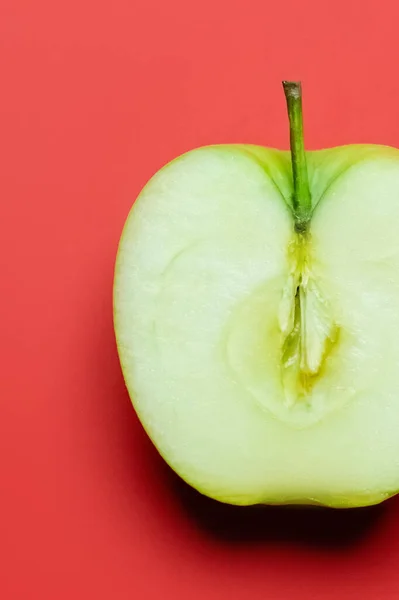 Vista de cerca de manzana fresca cortada sobre fondo rojo - foto de stock