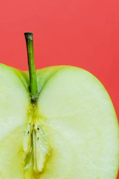 Close up view of organic cut apple isolated on red - foto de stock