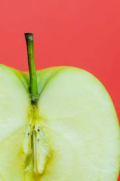 Close up view of organic cut apple isolated on red — Photo de stock